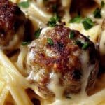 Easy Garlic Butter Meatballs Served Over Creamy Parmesan Linguine