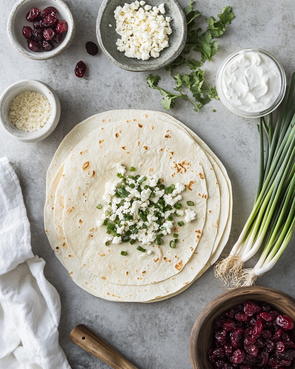 This image shows a wooden board with pinwheel sandwiches arranged in the shape of a Christmas tree. The pinwheels have a green outer layer, white cream cheese inside, and bits of red throughout, likely from cranberries or a similar ingredient. The tree shape is built from five layers of pinwheels, with the bottom layer having the most pieces and the top layer having just one. Small sprigs of green rosemary are placed between some of the pinwheels to look like tree branches. At the top of the tree, there is a bright yellow star-shaped piece of cheese. The background is a white marbled texture, and two black forks are placed near the bottom right of the board. Photo taken with an iphone --ar 4:5 --v 7