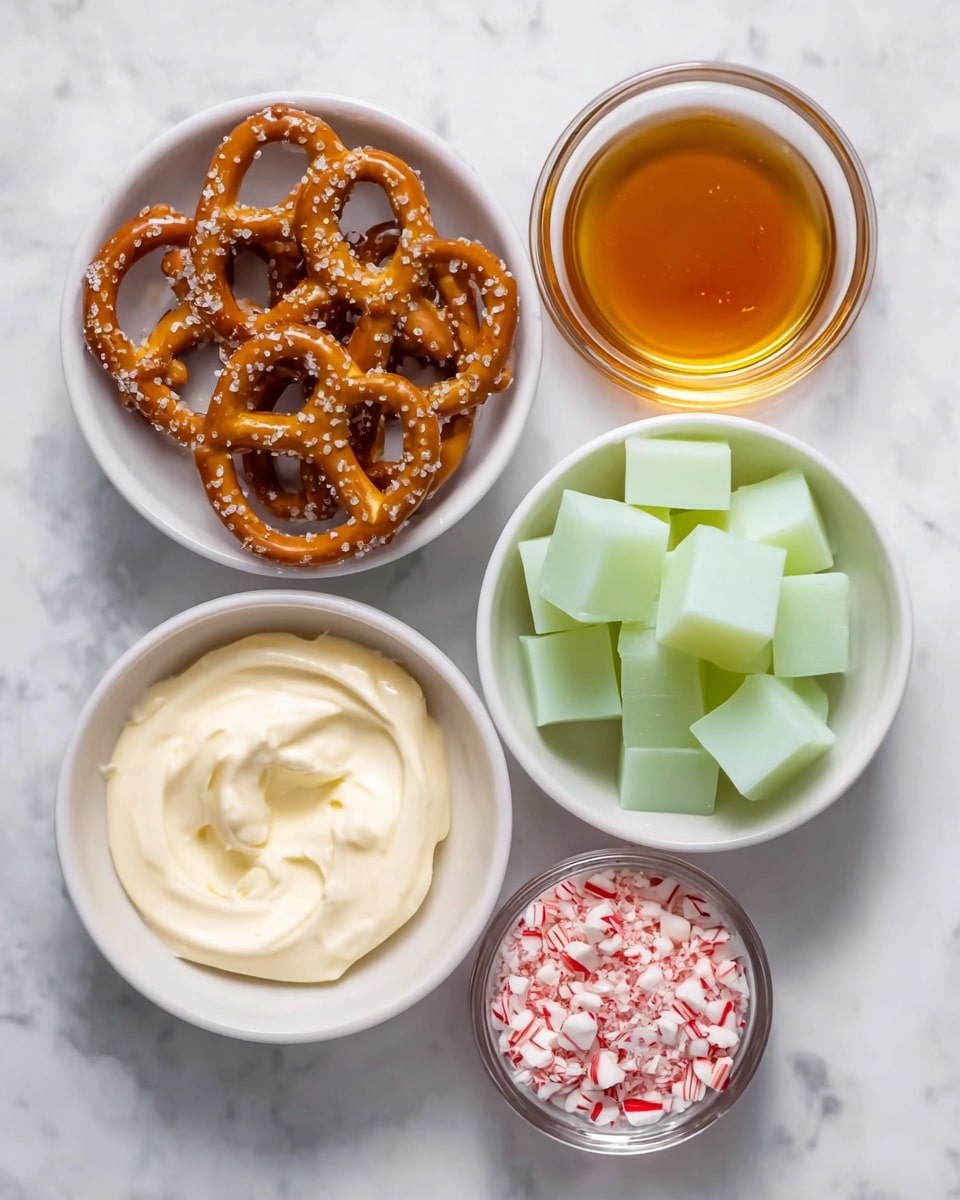 Grinch Pretzel Bites with Caramel and Candy Melts Recipe 4 Five white bowls arranged on a white marbled surface hold different ingredients. The top left bowl is filled with golden-brown pretzels sprinkled with coarse salt, showing their twisted, shiny texture. The top right small bowl contains pale green translucent cubes. Below that, a larger bowl has many pale yellow cubes with smooth edges. At the bottom left, a bowl holds a creamy, swirled white mixture with a smooth texture. The bottom right small bowl contains crushed peppermint candy pieces in white and red bits. Each bowl is clean and simple, highlighting the clear colors and textures of the ingredients. photo taken with an iphone --ar 4:5 --v 7